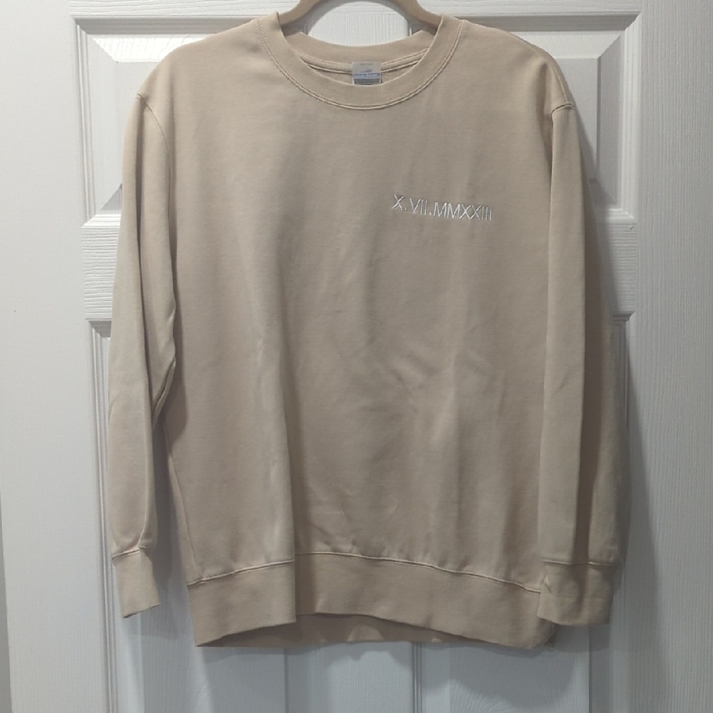 Beige Crewneck Sweater With the Roman Numerals Embroidered On It For 10/7/2023